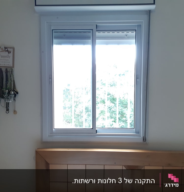 חלון אלומיניום עם מסגרת לבנה וקירבה למיטה